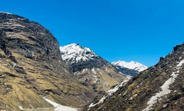 A breathtaking view of snowy mountains and blue skies in Manali, India, during winter.